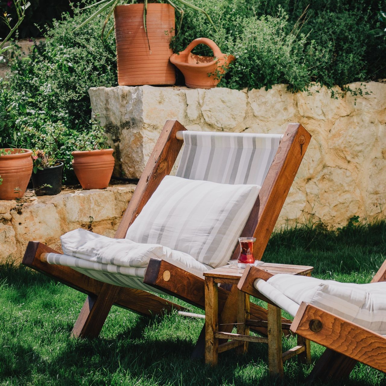 Coin détente jardin cosy les-rives-des-renards avec fauteuil bois et verdure luxuriante dans le Tarn