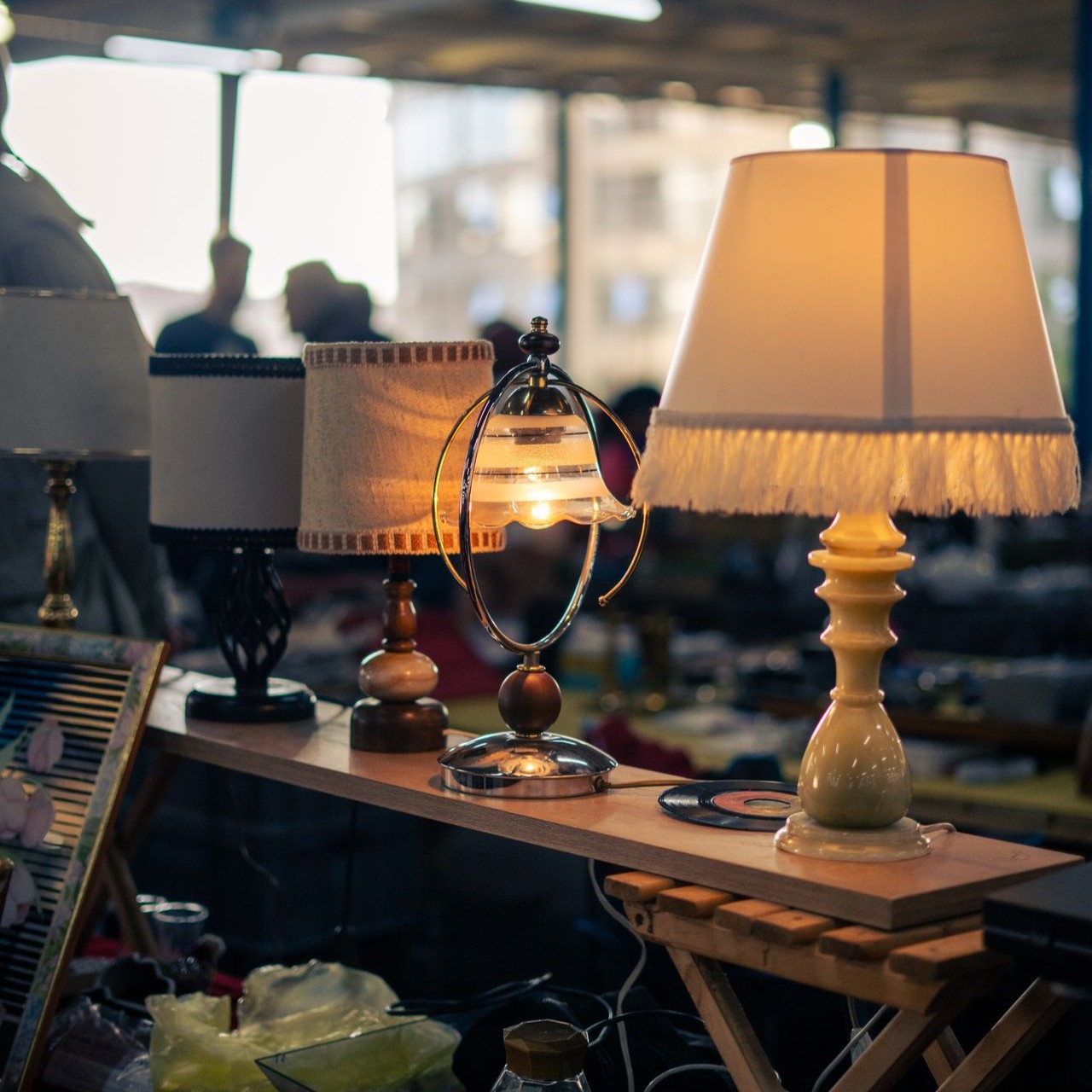 Lampes de table vintage allumées sur un stand rétro chez les-rives-des-renards, brocante chaleureuse dans le Tarn
