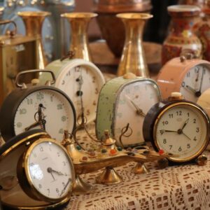 Réveils rétro et objets en laiton sur nappe de brocante les-rives-des-renards dans le Tarn